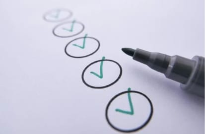 Picture showing pen and a piece of paper to indicate that learners can assess their own performance when preparing of the IELTS Speaking Test.